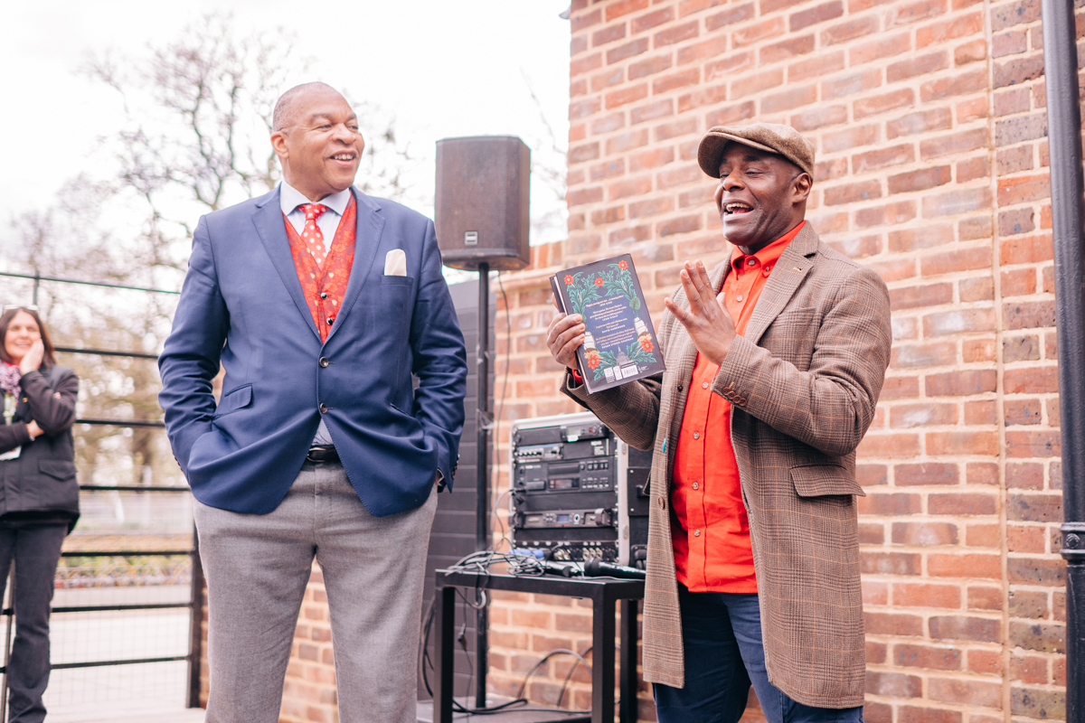 Wesley Kerr and Paterson Joseph are seen standing in front of the cafe building ask they speak at the opening event