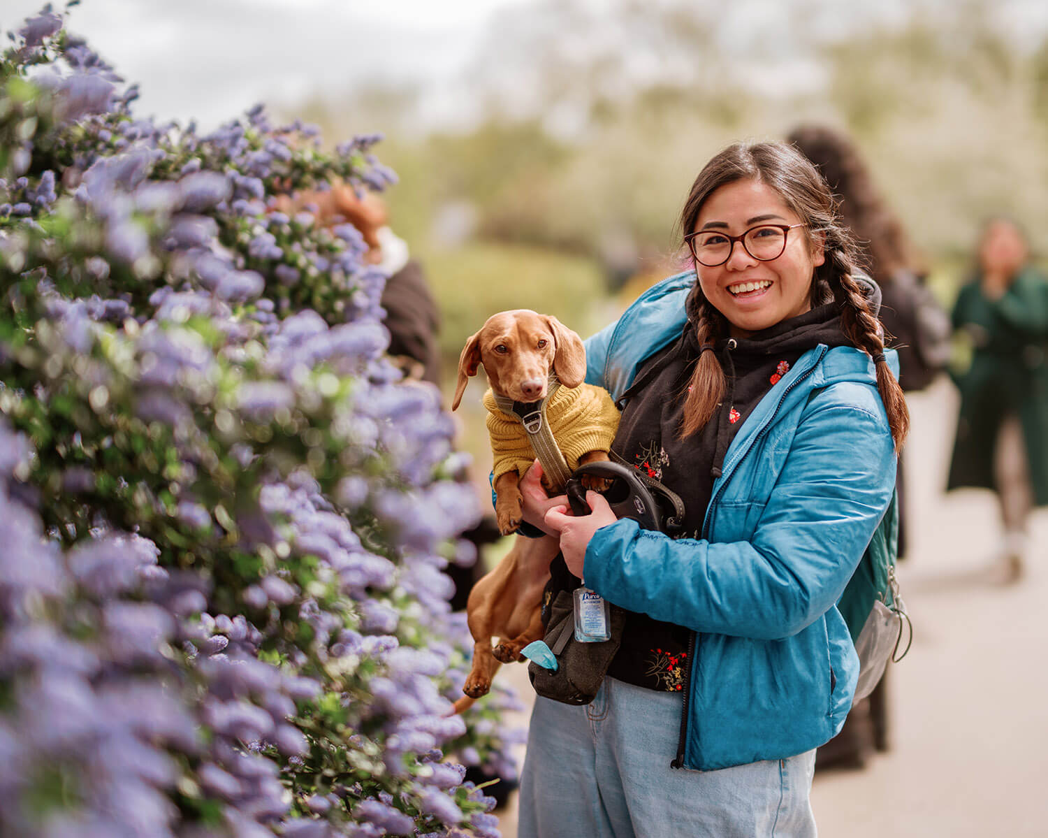 A young woman holding a small dog