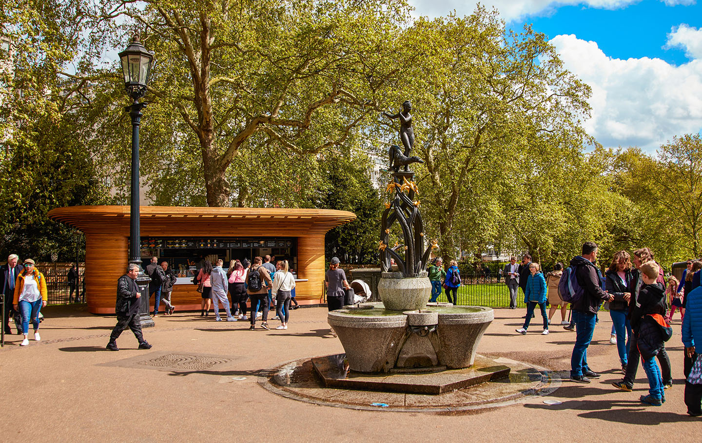 A busy food kiosk and decorative fountain in spring
