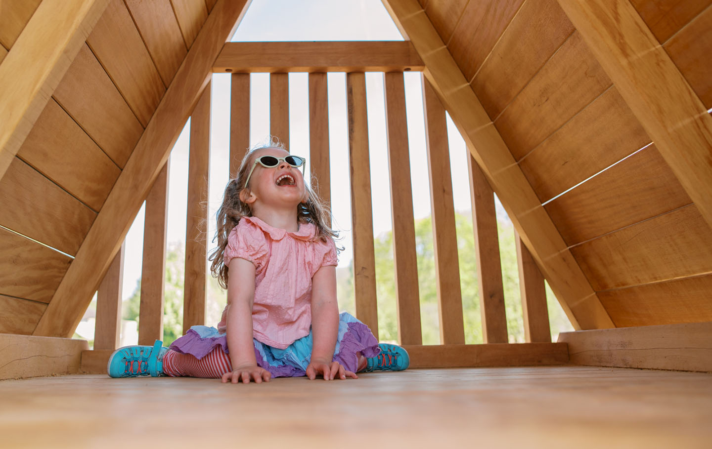 Young girl laughing under a play shelter