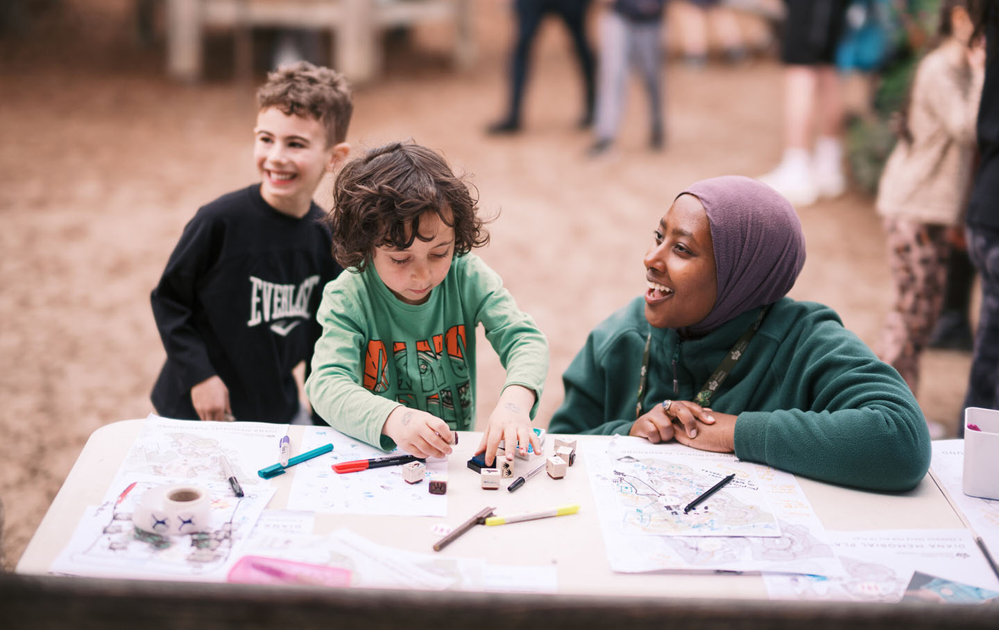 A Royal Parks Play Officer drawing with youngsters