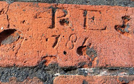 Letters scratched into the red brick of the Conduit House