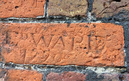 Letters scratched into the red brick of the Conduit House