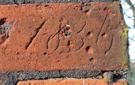 Letters scratched into the red brick of the Conduit House