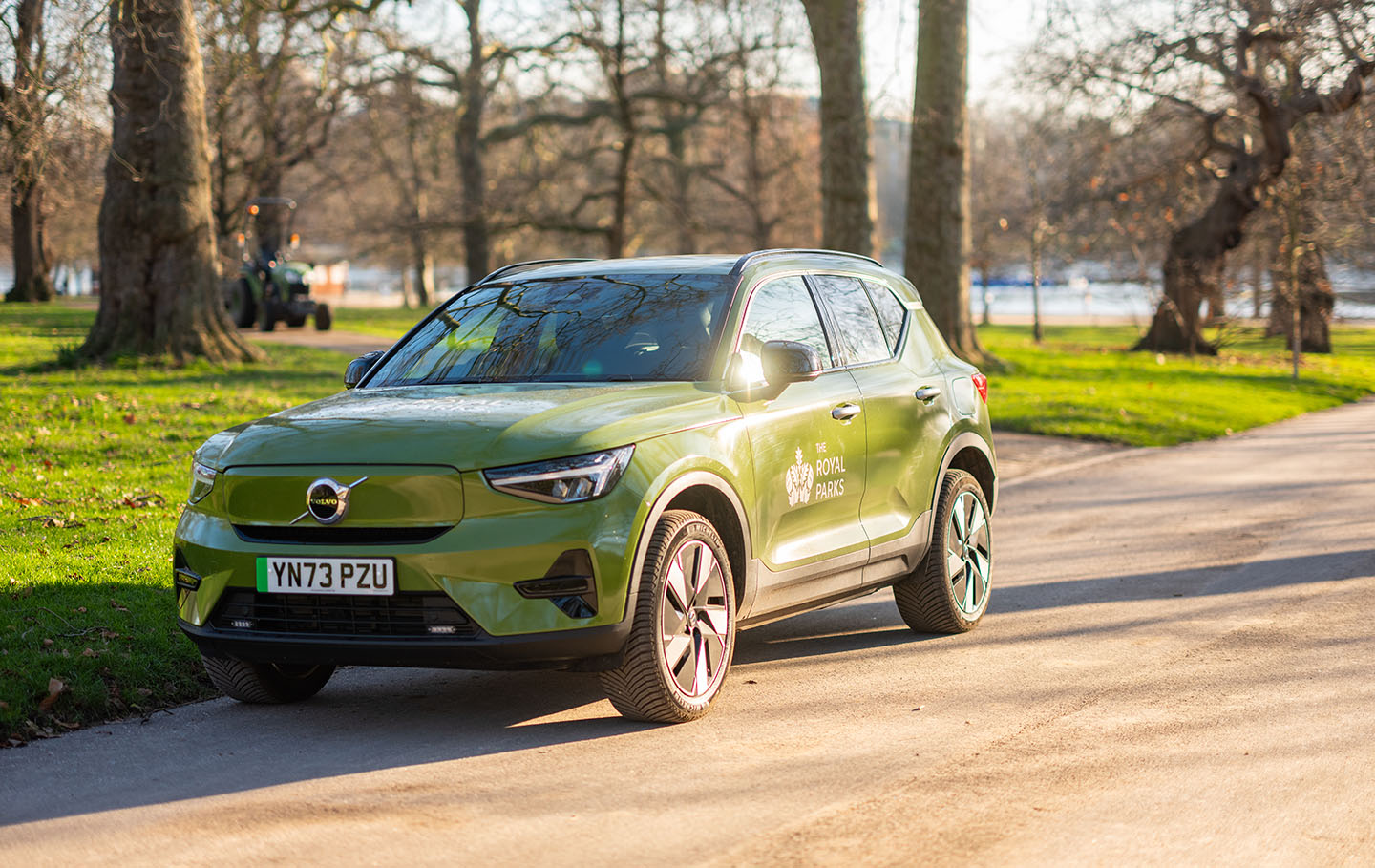 Green electric Volvo fleet car parked by the side of the road