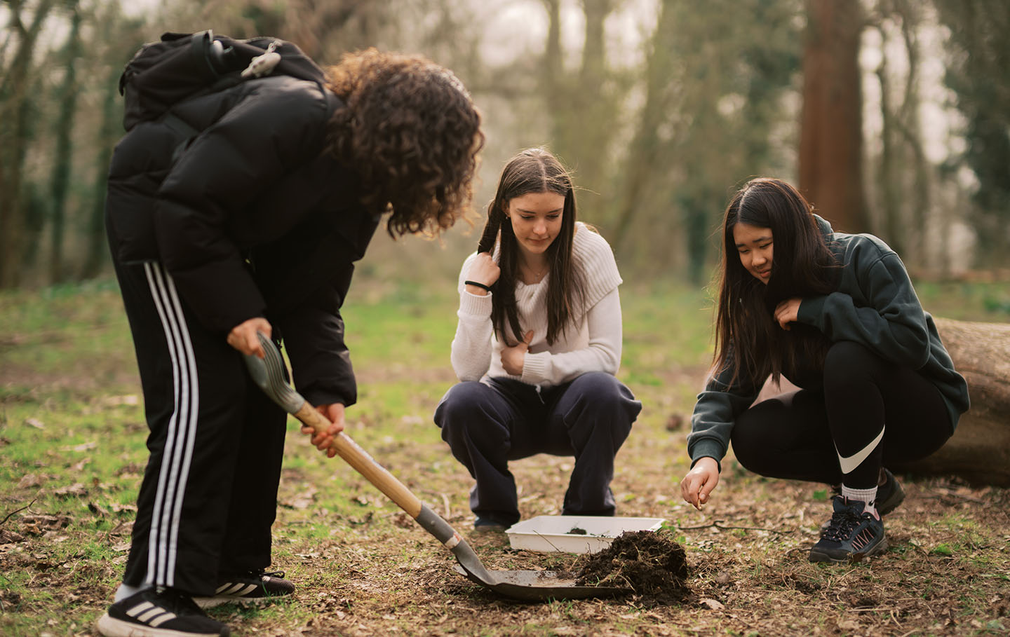 Three Green Futures students exploring soil samples