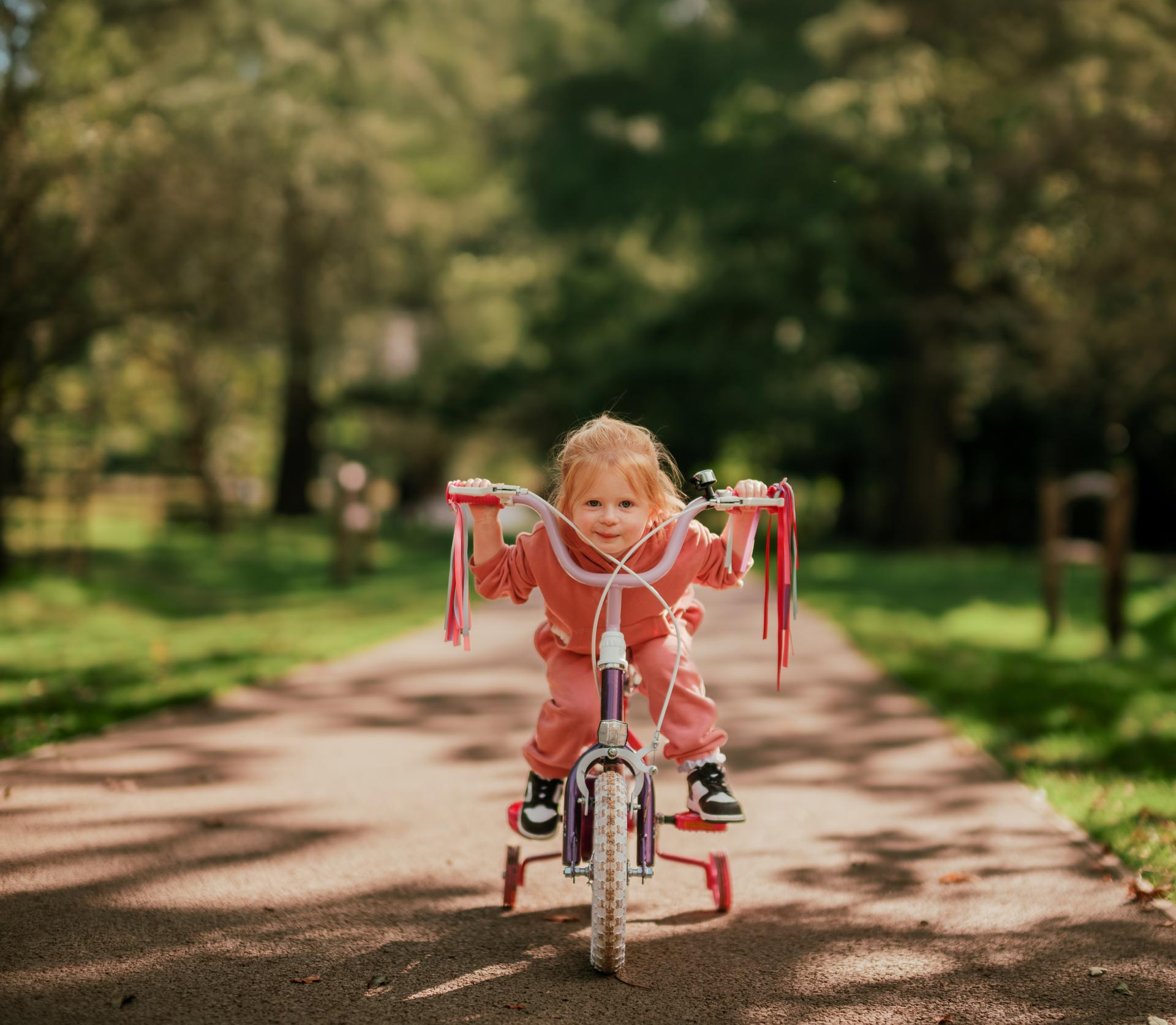 A young girl cycling through Bushy Park