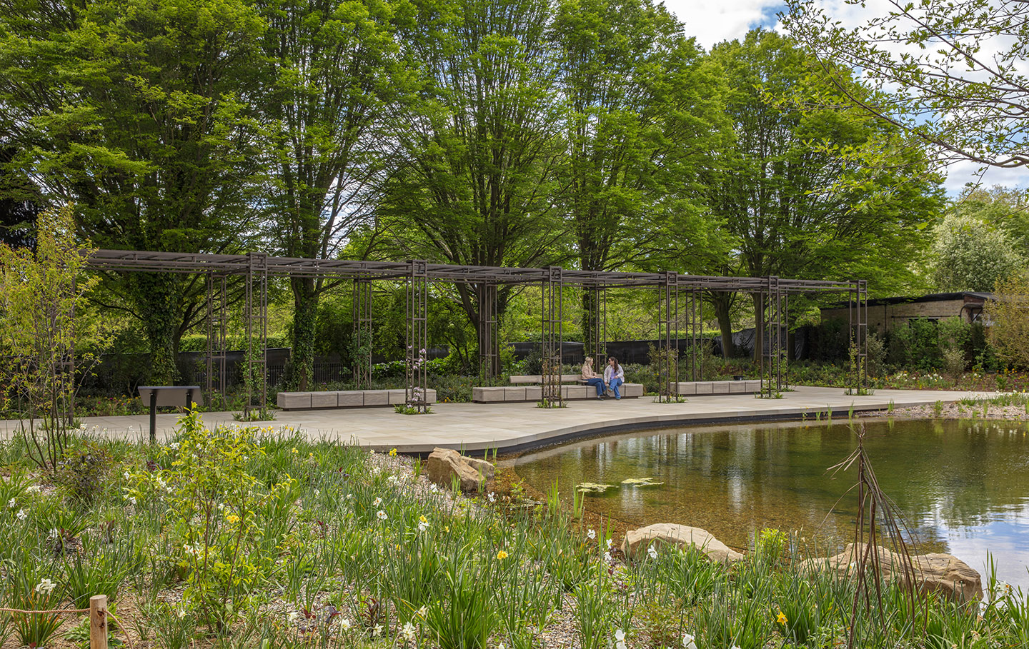 The large pergola uses repurposed metal from the original glasshouses