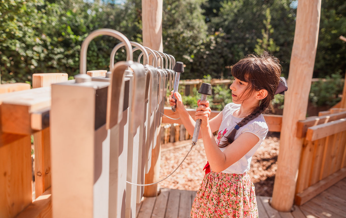 Young girl playing with the giant chimes