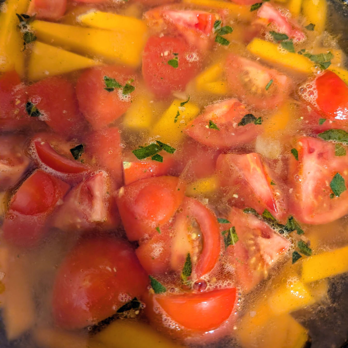 Squash and tomatoes simmering in vegetable stock