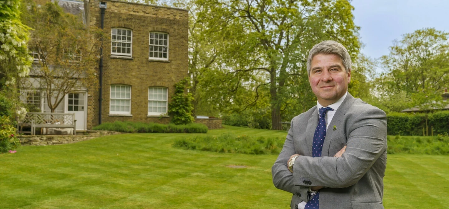 A man in a suit leaning against a bench