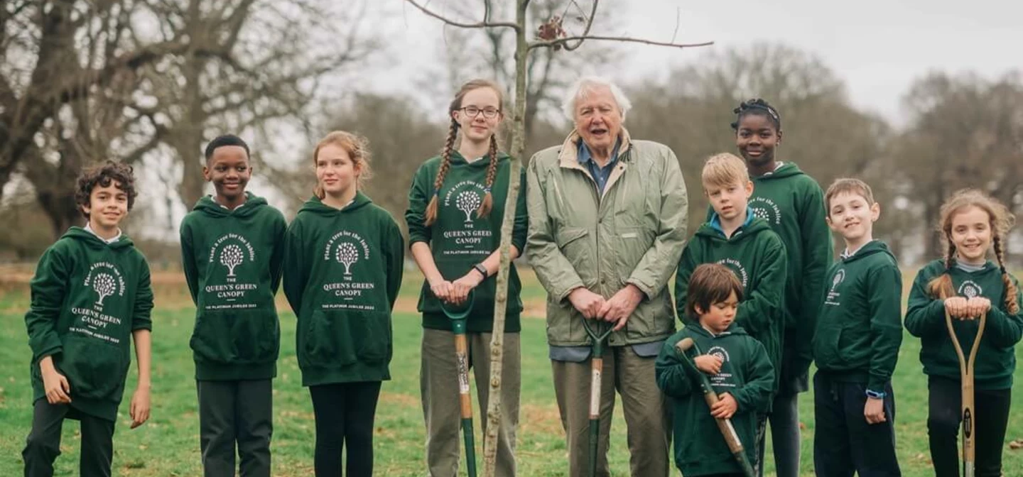 Sir David Attenborough planting a tree with school children