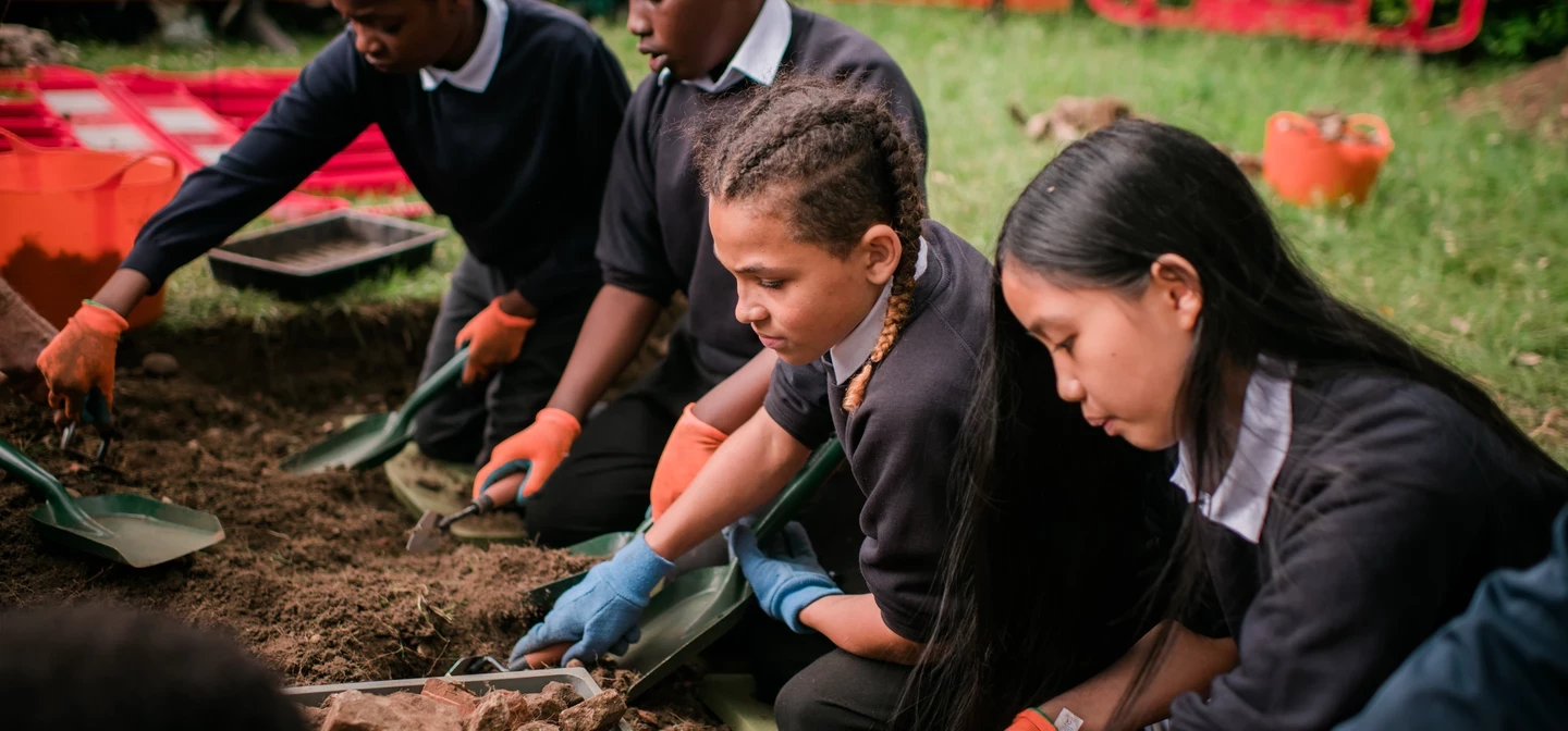 A group of children join in an archaeological dig