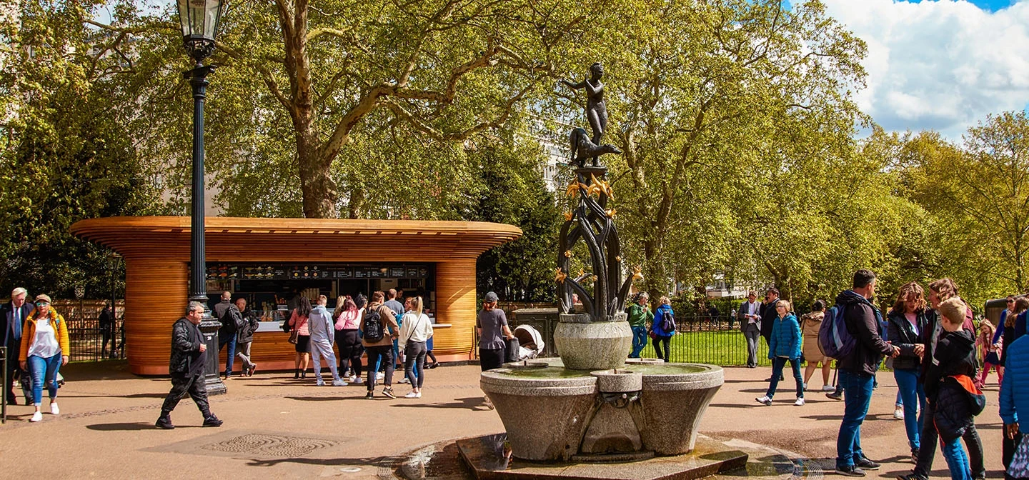 A busy food kiosk and decorative fountain in spring