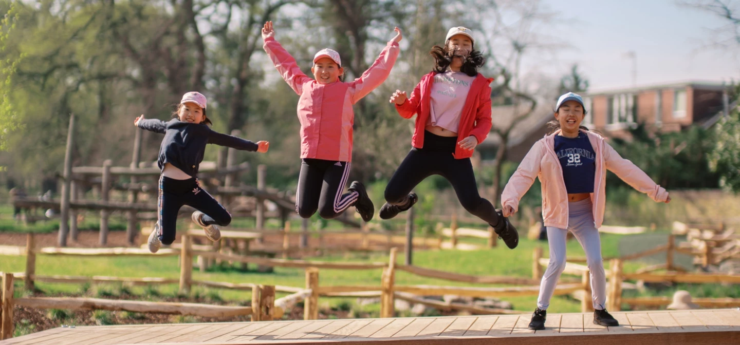 Children celebrating opening of Petersham Playground by jumping on play equipment 