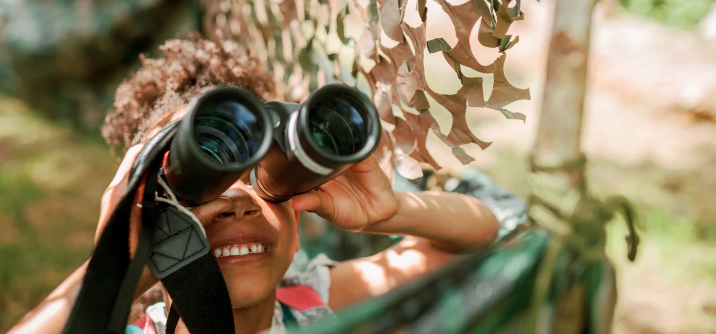 A child looks through binoculars