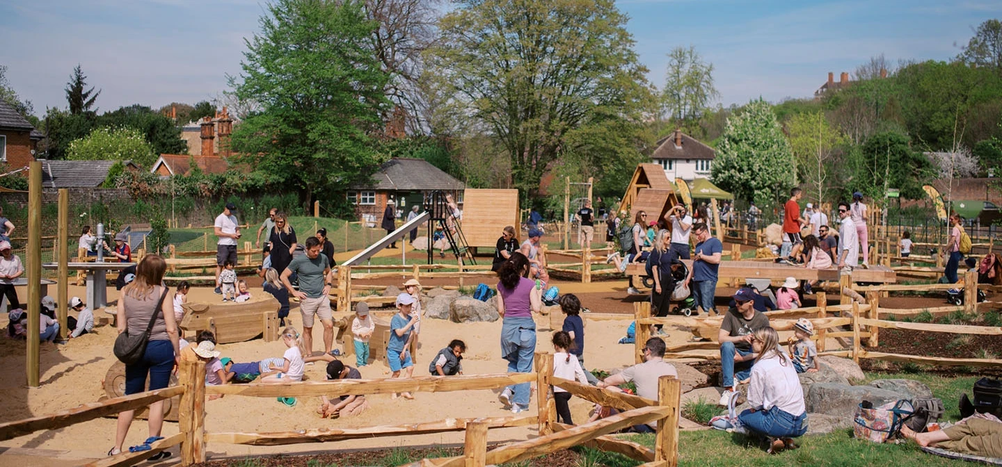Children and their parents enjoying a playground sandpit