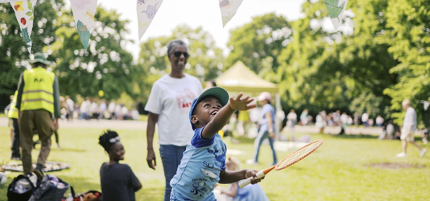 A young boy playing with a badminton racquet