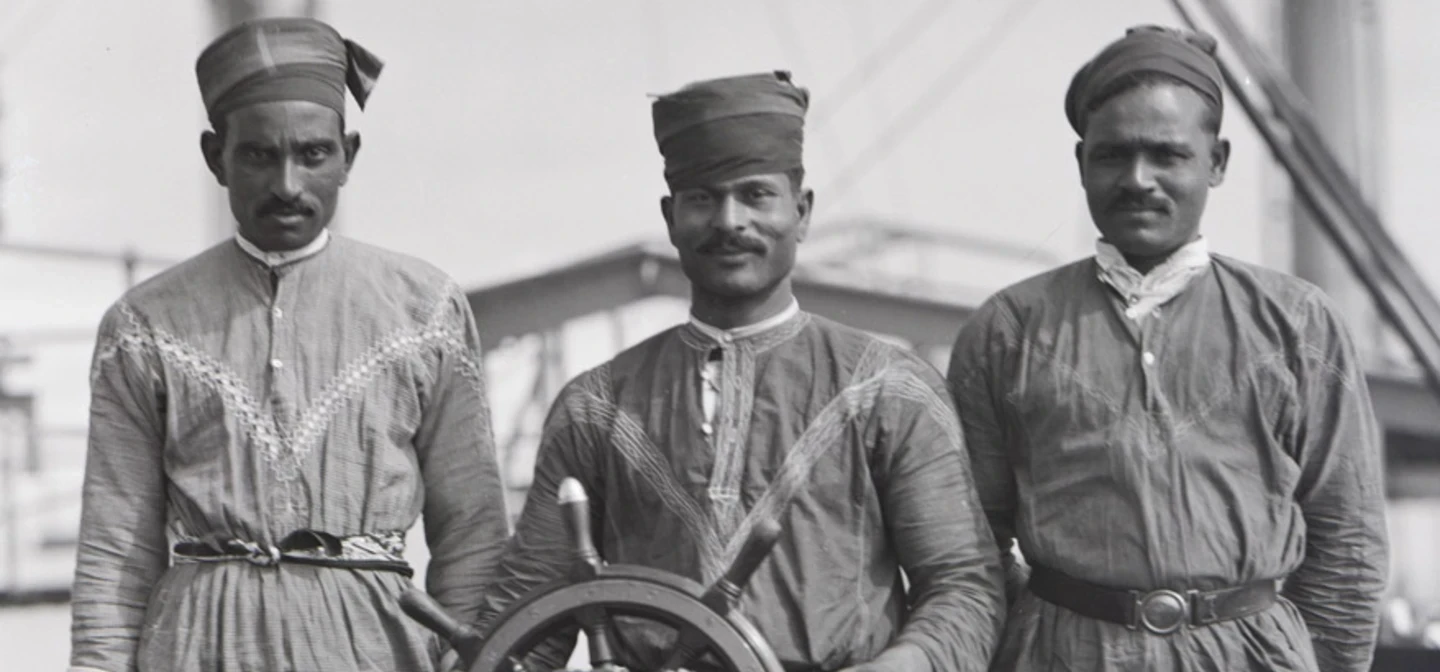 Black and white photo of 3 lascar sailors aboard a ship in 1929.
