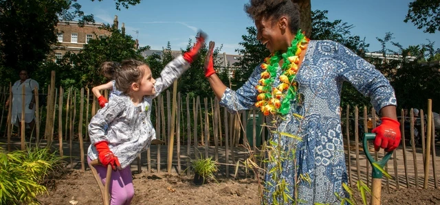 Woman and child digging in the flower beds