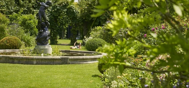 Sunbather and statue in St. John's Lodge Garden