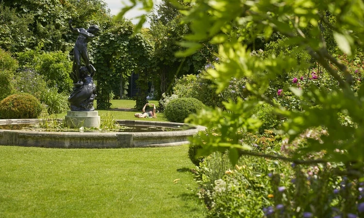 Sunbather and statue in St. John's Lodge Garden
