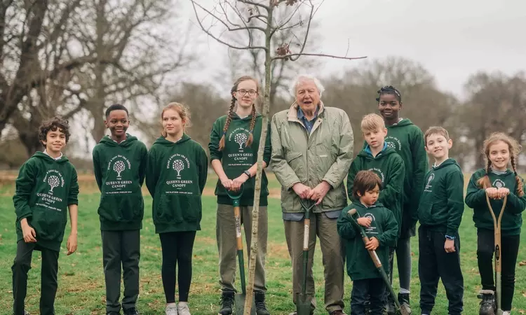 Sir David Attenborough planting a tree with school children 