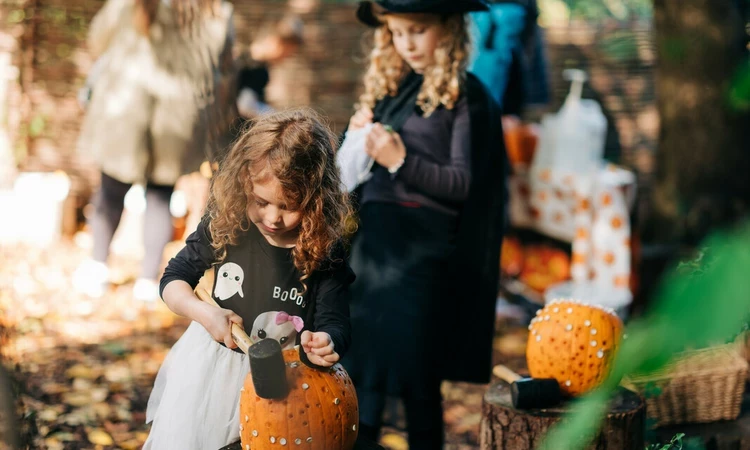 Children pumpkin carving in Halloween themed activities