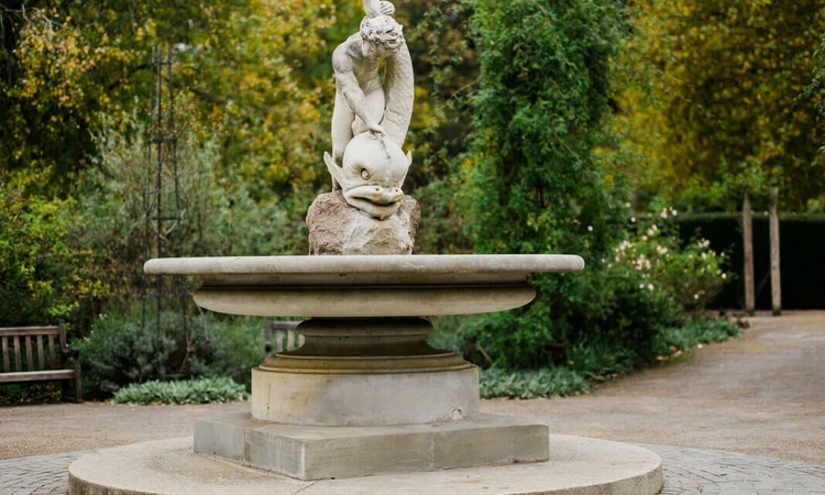 Boy and Dolphin Fountain statue in the Hyde Park rose garden in autumn