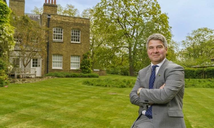 A man in a suit leaning against a bench