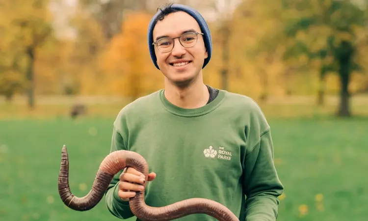 Member of staff holding giant model of giant earthworm
