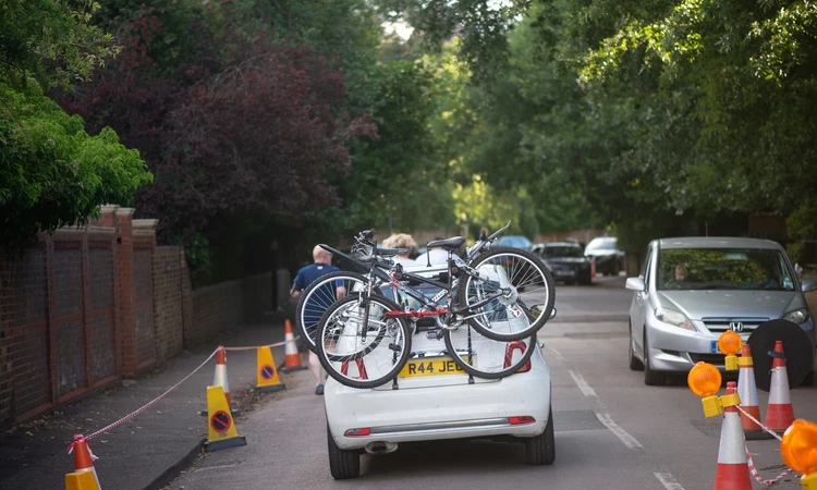 The back of a car driving through Richmond Park, bicycles are on the back of the vehicle