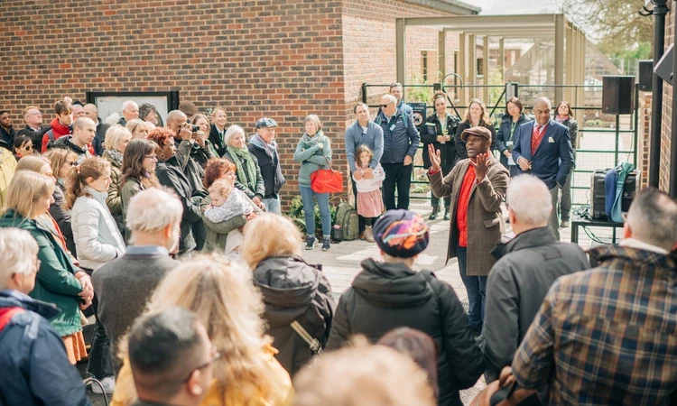 A group of people surrounding actor, Paterson Joseph, as he speaks about Ignatius Sancho