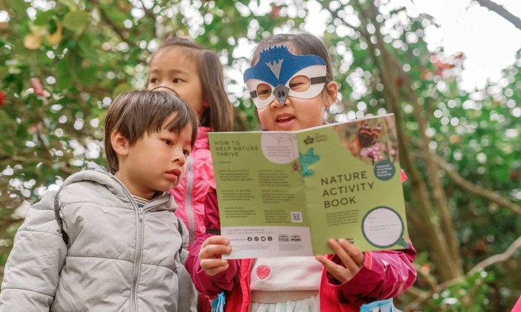 Children looking at a Nature Activity Book