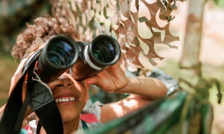 A child looks through binoculars
