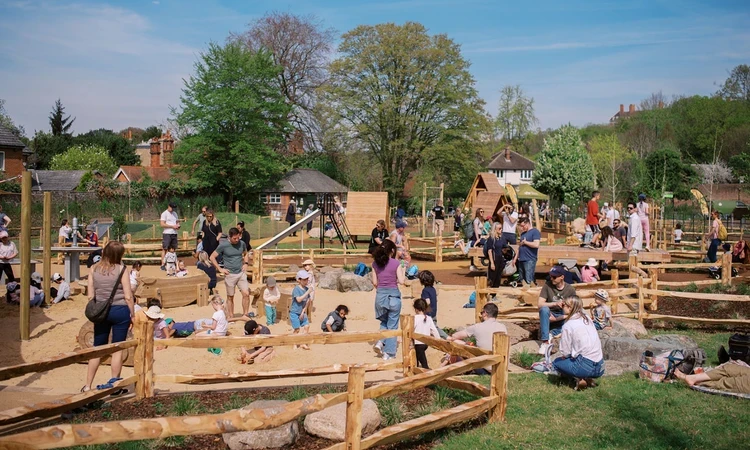 Children and their parents enjoying a playground sandpit