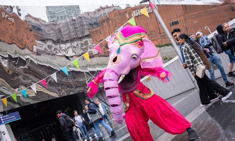 Image of a pink Ganesha figure in an outdoor, festival setting