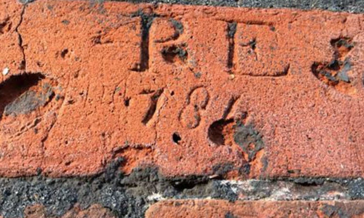 Letters scratched into the red brick of the Conduit House