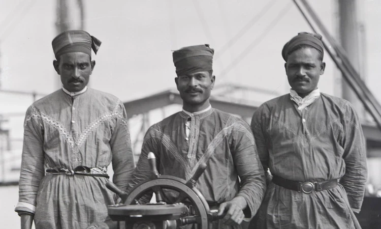 Black and white photo of 3 lascar sailors aboard a ship in 1929.