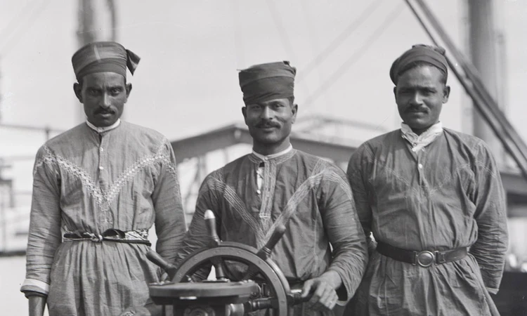 Black and white photo of 3 lascar sailors aboard a ship in 1929.