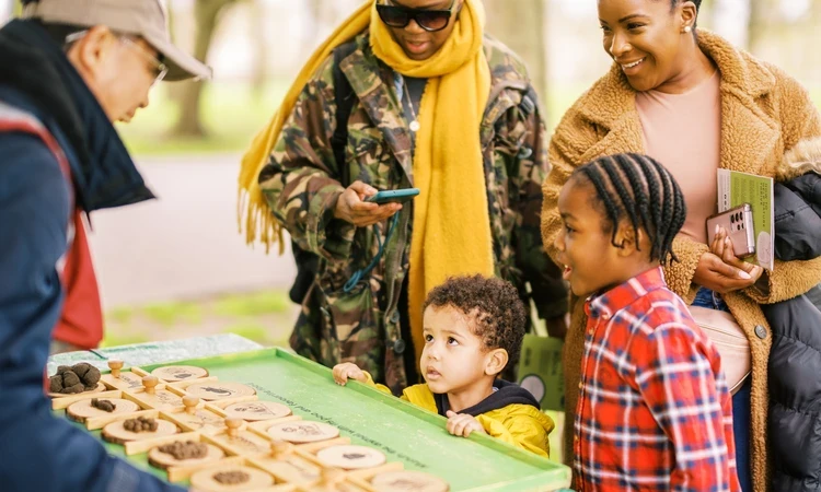 A family playing a quiz matching fake poos to the animal who do them