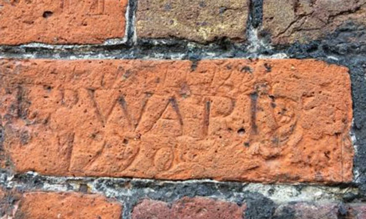 Letters scratched into the red brick of the Conduit House