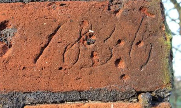 Letters scratched into the red brick of the Conduit House