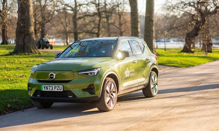 Green electric Volvo fleet car parked by the side of the road