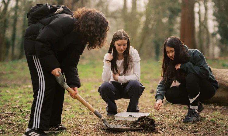 Three Green Futures students exploring soil samples