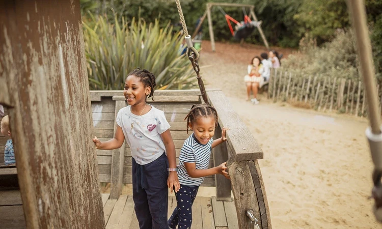 Two girls playing on the wooden galleon
