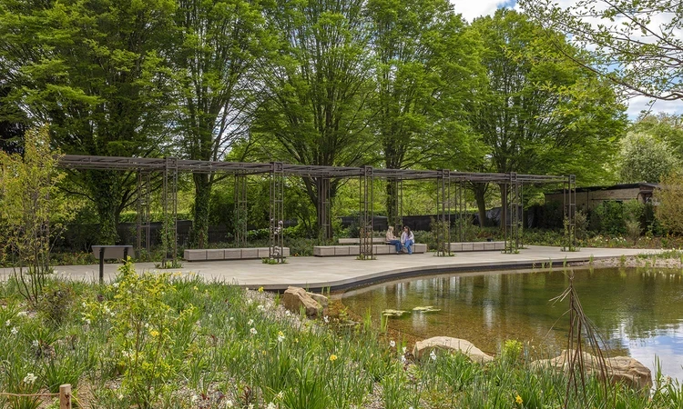 The large pergola uses repurposed metal from the original glasshouses