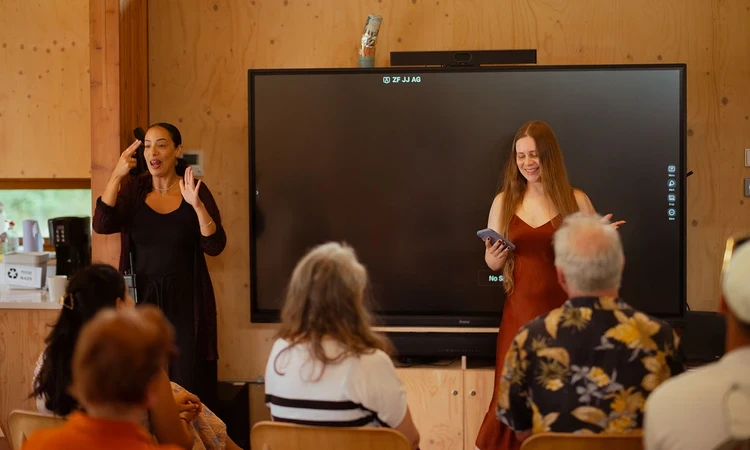 Artist Leah Clements presents 'The Very Alive Part' to an audience, with BSL Interpreter Sumayya Si-Tayeb