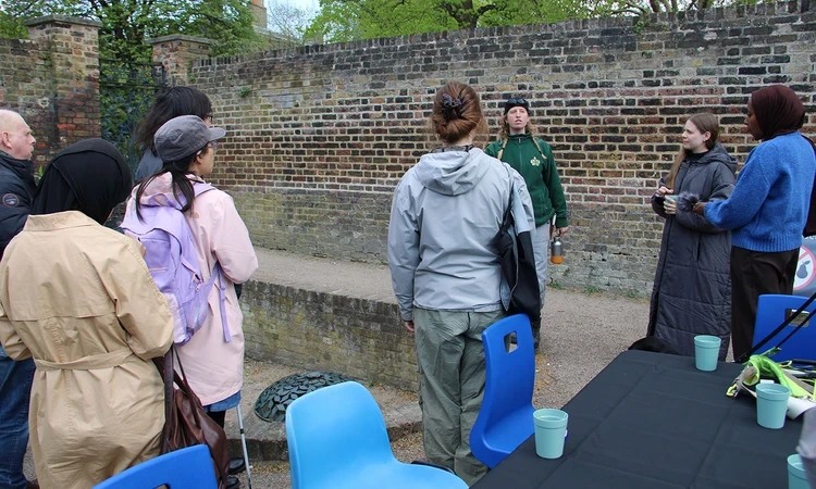 Artist Leah Clements talking to a group in the Queen's Orchard