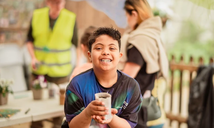 Young boy with a newspaper plant pot